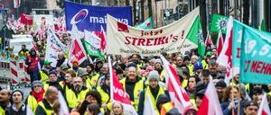 Streikende Demonstranten mit Transparenten ziehen am Vormittag durch die Frankfurter Innenstadt. 