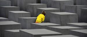 Ein Kind spielt Verstecken am Denkmal für die ermordeten Juden Europas in Berlin-Mitte.