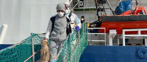 HANDOUT - 17.02.2023, Italien, Ancona: Migranten gehen von Bord der «Geo Barents», die im Hafen von Ancona in Mittelitalien liegt. Die private Hilfsorganisation Ärzte ohne Grenzen hat in Ancona 48 Bootsmigranten an Land gebracht. Das Schiff habe den Hafen nach einer tagelangen Überfahrt am Freitagmittag erreicht, teilte die Organisation am Freitag, 17.02.2023 mit. Sie waren am Montag, 13.02. im zentralen Mittelmeer nahe der libyschen Küste aus Seenot gerettet und an Bord der «Geo Barents» geholt worden. Unter ihnen befanden sich den Angaben zufolge neun Minderjährige. Foto: -/MSF/dpa - ACHTUNG: Nur zur redaktionellen Verwendung im Zusammenhang mit einer Berichterstattung und nur mit vollständiger Nennung des vorstehenden Credits +++ dpa-Bildfunk +++