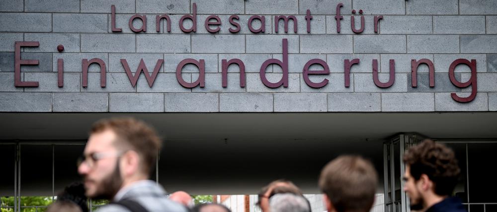 Menschen stehen vor dem Berliner Landesamt für Einwanderung. 