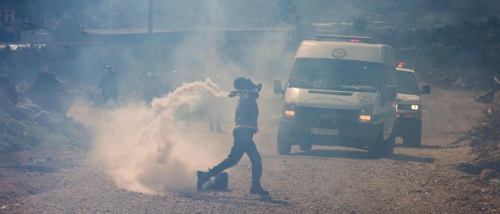 Ein palästinensischer Demonstrant wirft einen Stein auf israelische Sicherheitskräfte während einer Demonstration in Nablus am 24. Februar 2023.
