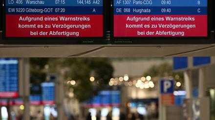 Auf den Bildschirmen im Flughafen Düsseldorf wird auf einen Warnstreik hingewiesen. 