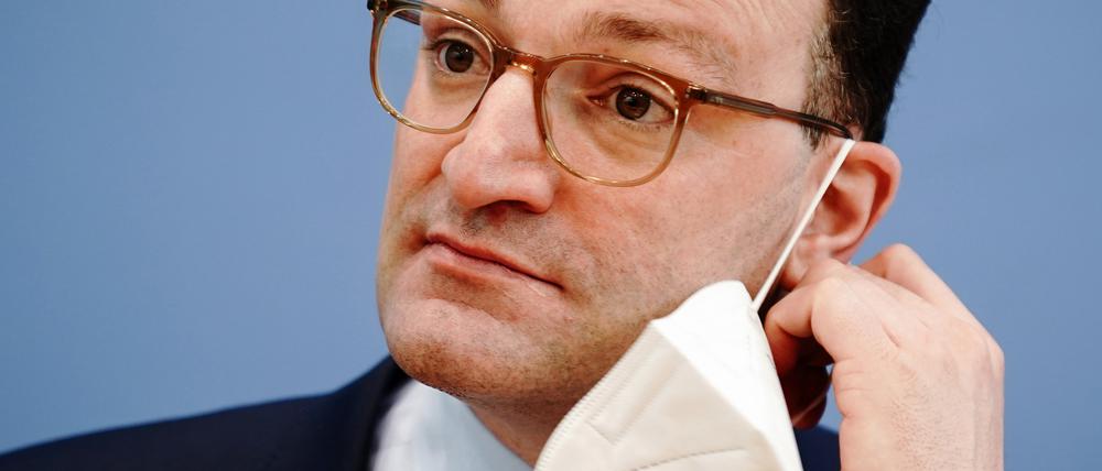 Jens Spahn (CDU), damaliger Bundesminister für Gesundheit, nimmt zu Beginn der Pressekonferenz zur Corona-Lage vor Ostern die FFP2-Maske ab.