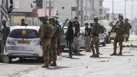 Jüdische Siedler protestieren, während die israelische Armee in der Stadt Hawara Wache hält. Zahlreiche israelische Siedler randalierten im nördlichen Westjordanland und setzten Autos und Häuser in Brand.