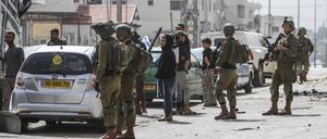 Jüdische Siedler protestieren, während die israelische Armee in der Stadt Hawara Wache hält. Zahlreiche israelische Siedler randalierten im nördlichen Westjordanland und setzten Autos und Häuser in Brand.