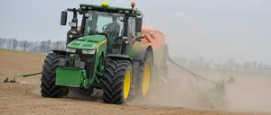 Ein Mann drillt auf einem Feld mit dem Traktor in den trockenen Boden eine Zwischenfrucht zur Bodenverbesserung. 