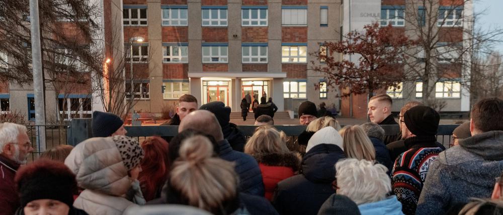 Bürger stehen vor dem verschlossenen Zugang zu Schule „Caspar David Friedrich“. Hier befasst sich die Sitzung der Ortsteilvertretung Ostseeviertel mit dem geplanten Bau einer Unterkunft für 500 Flüchtlinge.