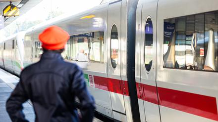 Ein DB-Mitarbeiter steht neben einem ICE-Zug an einem Gleis im Hauptbahnhof Hannover.