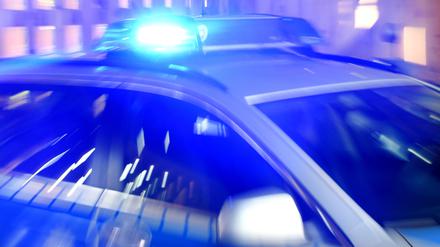 Ein Streifenwagen der Polizei steht mit eingeschaltetem Blaulicht auf der Straße (Symbolbild).