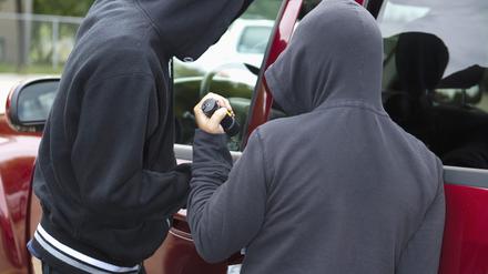Zwei Männer brechen ein Auto auf. (Symbolbild)