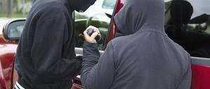 Zwei Männer brechen ein Auto auf. (Symbolbild)