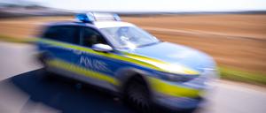 Ein Polizeiauto fährt über eine Dorfstraße (Symbolbild).