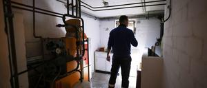 Ein Mitarbeiter eines Diesel- und Heizöl-Unternehmens prüft die Kunststofftanks in einem Heizungskeller bei der Heizöllieferung für ein Einfamilienhaus. 