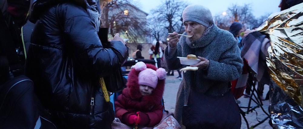 Flüchtlinge bekommen eine Mahlzeit.