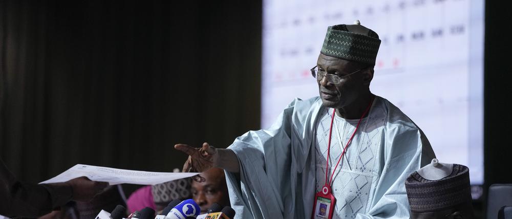 01.03.2023, Nigeria, Abuja: Mahmood Yakubu, Vorsitzender der Unabhängigen Nationalen Wahlkommission (INEC), nimmt ein Dokument entgegen, während die Ergebnisse für die einzelnen Bundesstaaten im Nationalen Auszählungszentrum verlesen werden. Foto: Ben Curtis/AP +++ dpa-Bildfunk +++