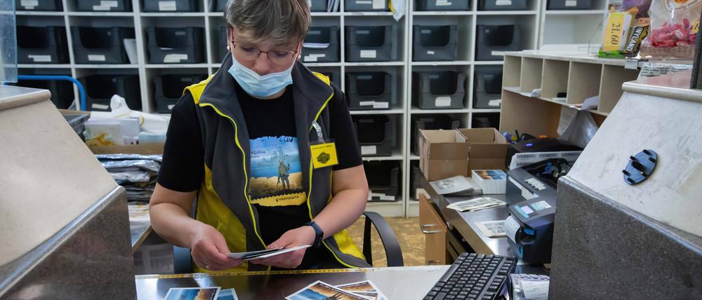 Eine Postangestellte verkauft in einem Postamt in Kiew Briefmarken und Postkarten (Symbolbild).