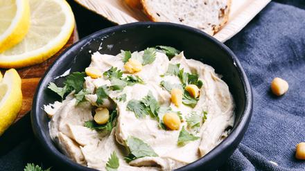 Delicious hummus on the table , 15849062.jpg, hummus, food, bowl, snack, appetizer, vegan, vegetable, cuisine, chickpea, creamy, fresh, paste, delicious, olive, dip, oil, arabic, white, dipping, background, healthy, tahini, traditional, meal, arabian, lunch, levantine, spread, natural, nutrition, close-up, texture, cooking, eating, eat, kitchen, breakfast, dinner, parsley, greens, table, rural, rustic, blue, tablecloth, lemon, dish, bread, tray, wooden,