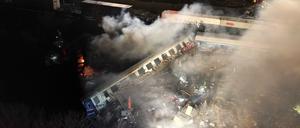 Rauch steigt auf, während Feuerwehrleute und Rettungskräfte nach einem Zusammenstoß zweier Züge in der Nähe von Larisa im Einsatz sind.
