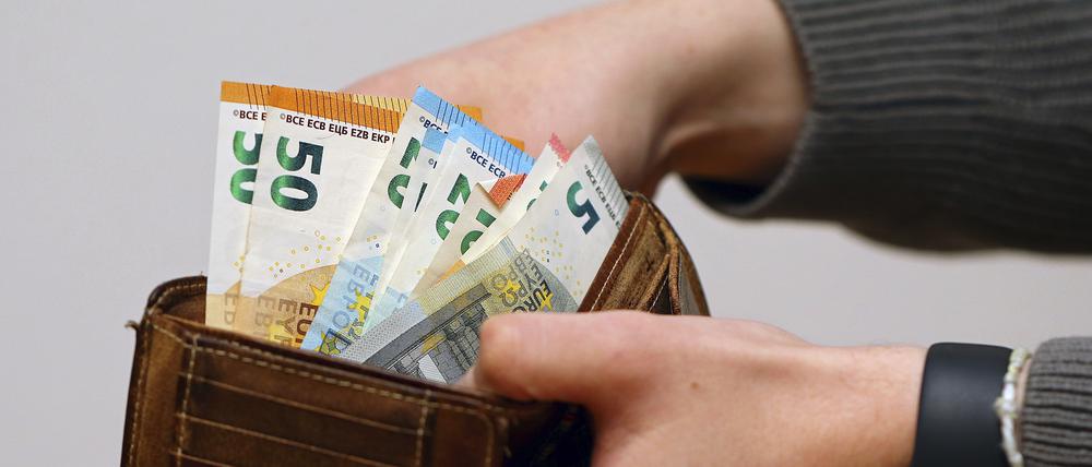 Symbolbild: Eine Frau zählt ihre Geldscheine ihrem Portemonnaie. In Zeiten von steigenden Energiekosten müssen viele Bürger den sparen.