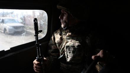 Ein ukrainischer Soldat schaut aus einem Fahrzeug während einer Fahrt durch Bachmut (Symbolbild).