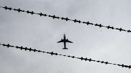 Ein Flugzeug ist hinter Stacheldraht zu sehen. 