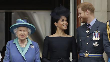 Die britische Königin, Queen Elizabeth II., ihr Enkel Prinz Harry und seine Frau Herzogin Meghan stehen beim Vorbeiflug von Flugzeugen der Royal Air Force über den Buckingham-Palast auf einem Balkon. 