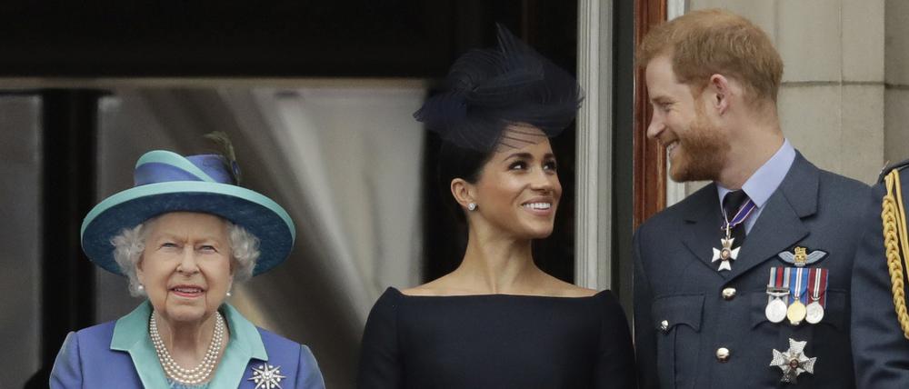Die britische Königin, Queen Elizabeth II., ihr Enkel Prinz Harry und seine Frau Herzogin Meghan stehen beim Vorbeiflug von Flugzeugen der Royal Air Force über den Buckingham-Palast auf einem Balkon.