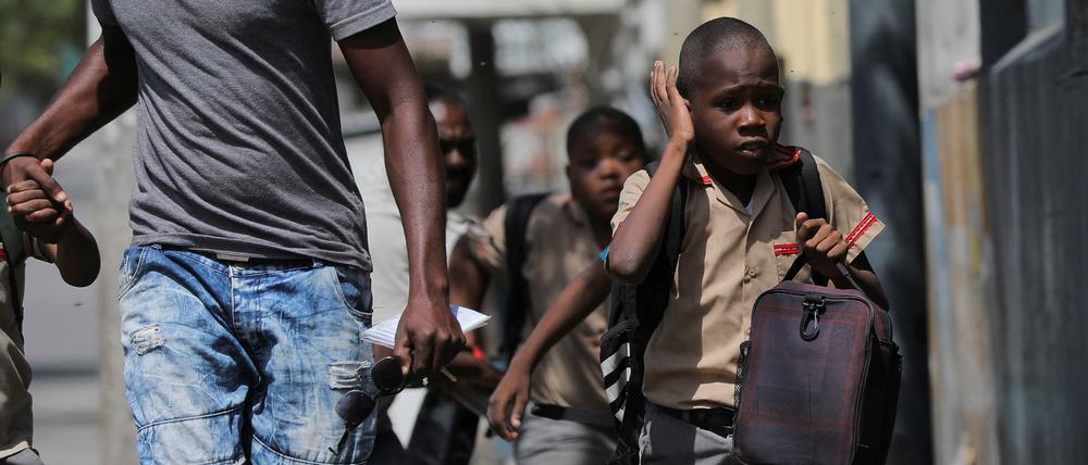 A child gestures as he looks for cover after leaving school amid gang violence in Port-au-Prince, Haiti March 3, 2023. REUTERS/Ralph Tedy Erol