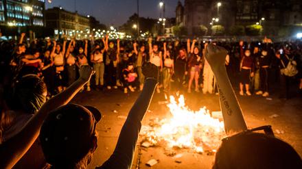 Demonstrierende Frauen versammeln sich um ein Feuer am Zocalo in Mexiko City, Mexiko.