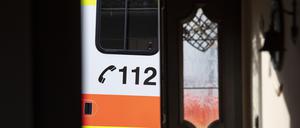 Ein Rettungswagen parkt bei einem Einsatz von Notfallsanitätern des Deutschen Roten Kreuzes (DRK) vor der geöffneten Tür eines Wohnhauses.