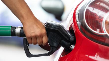 Eine Frau tankt an einer Tankstelle. Verbraucherinnen und Verbraucher zahlen den CO₂-Preis beim Tanken und Heizen.