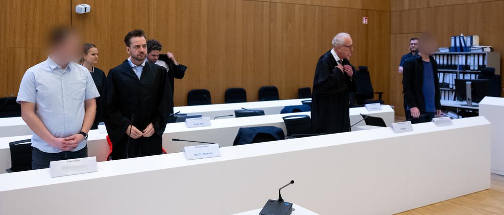 Die zwei wegen Mordes angeklagten Männer (l. und r.) stehen vor Beginn der Verhandlung im Hochsicherheitsgerichtssaal vom Landgericht München II neben ihren Rechtsanwälten Sarah Stolle (2.v.l.), Alexander Stevens (3.v.l.), Alexander Betz (4.v.l.) und Gerhard Bink (5.v.l.).