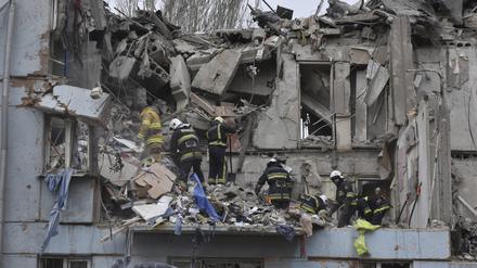 Feuerwehrleute des staatlichen ukrainischen Katastrophenschutzes inspizieren ein beschädigtes Haus nach einem russischen Raketeneinschlag. 