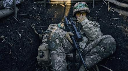 Ein ukrainischer Soldat sitzt in einem Graben in der Nähe russischer Stellungen bei Bachmut.