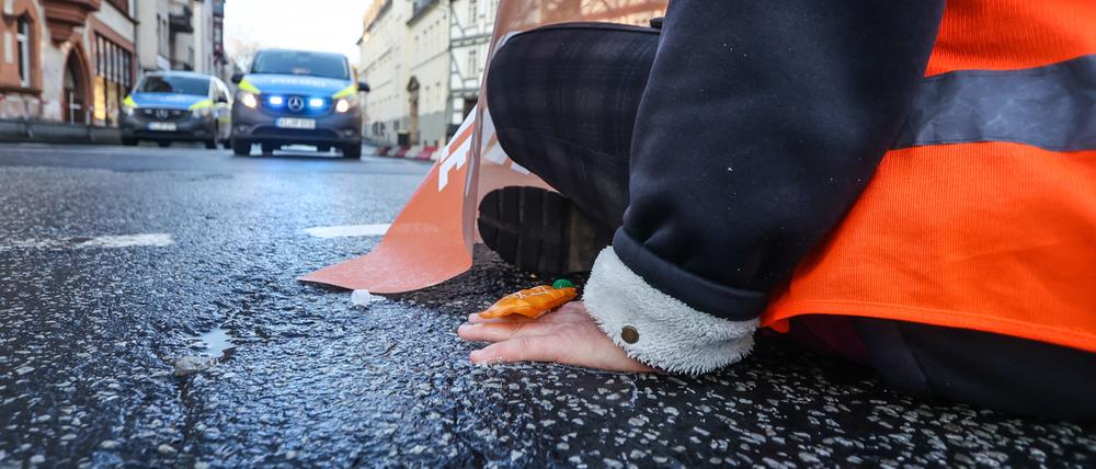 Klimaaktivisten haben sich im mittelhessischen Marburg auf die Straße gesetzt und dort festgeklebt. 