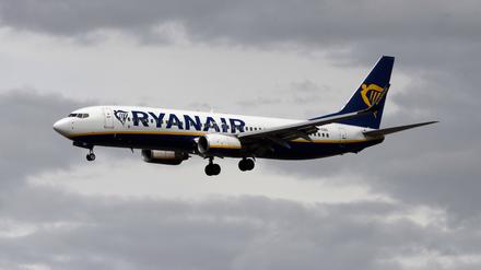 Eine Passagiermaschine von Ryanair setzt vor dunklen Wolken zum Landeanflug auf den Flughafen Frankfurt an.