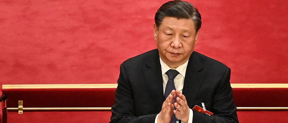 China's President Xi Jinping (R) and Politburo Standing Committee member Li Qiang applaud during the second plenary session of the National People's Congress (NPC) at the Great Hall of the People in Beijing on March 7, 2023. (Photo by Greg Baker / AFP)