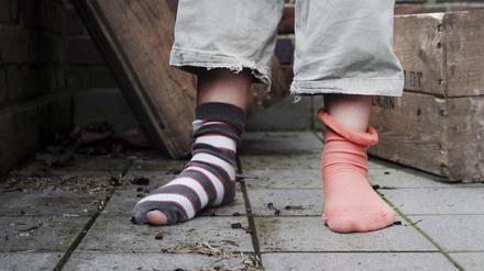 ARCHIV: Ein zehn Jahre altes Mädchen steht in abgetragener Kleidung ohne Schuhe in einem Hinterhof in Hamburg it