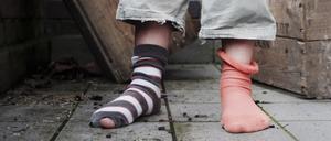 ARCHIV: Ein zehn Jahre altes Mädchen steht in abgetragener Kleidung ohne Schuhe in einem Hinterhof in Hamburg it