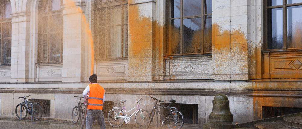 An activist of "Letzte Generation" (Last Generation) spray paints on the building of the German transport ministry calling for a speed limit on highways and affordable public transport, in Berlin, Germany, March 7, 2023. REUTERS/Christian Mang
