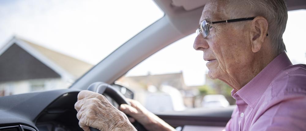 Ein Senior hinter dem Steuer eines Autos.