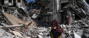 Eine Frau steht vor den Trümmern eines Hauses in Hatay. 