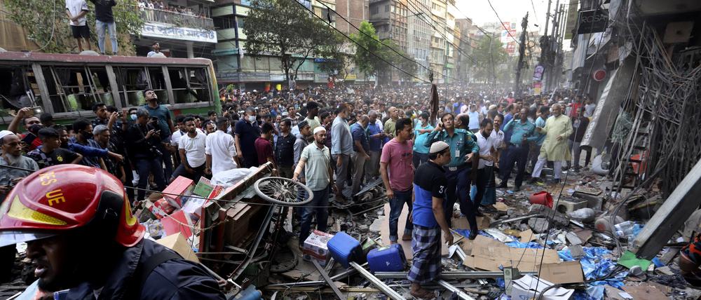 Menschen versammeln sich vor dem Ort einer Explosion. 