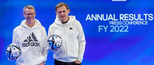 08.03.2023, Bayern, Herzogenaurach: Harm Ohlmeyer (l.), Finanzvorstand des Sportartikelherstellers adidas AG, und Björn Gulden, Vorstandsvorsitzender von Adidas, halten am Rande der Bilanz-Pressekonferenz des Unternehmens den offiziellen Spielball „OCEAUNZ“ der Fußball-Weltmeisterschaft der Frauen in Australien und Neuseeland 2023 in den Händen. Foto: Daniel Karmann/dpa +++ dpa-Bildfunk +++