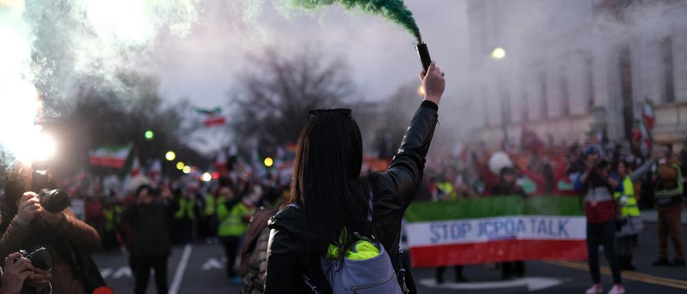 Ein Demonstrant hält eine grüne Rauchfackel während einer Demonstration am Lincoln Memorial in Washington, D.C., um die iranische Regierung zu verurteilen.