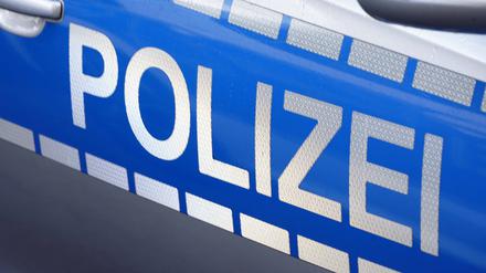 Schriftzug der Polizei an Polizeifahrzeug. (Symbolbild)