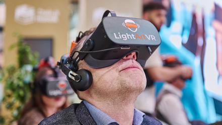 Am Stand von Saudi-Arabien blickt ein Mann durch eine 3D-Brille.