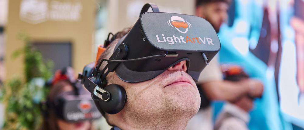 Am Stand von Saudi-Arabien blickt ein Mann durch eine 3D-Brille.