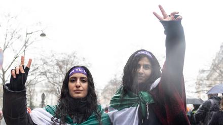 Zwei Frauen umwickelt mit der iranischen Flagge.