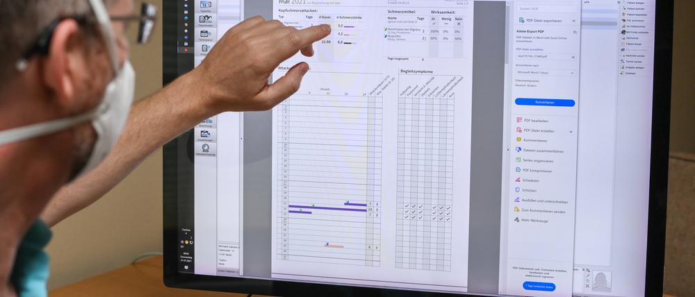 Ein Facharzt arbeitet mit einer elektronischen Patientenakte, die ein E-Rezept zeigt.